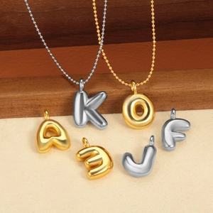 Vue détaillée de pendentifs lettres style ballon dorés et argentés, finition polie