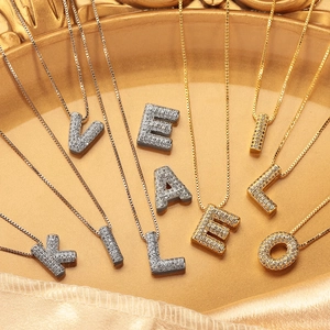 Vue détaillée des pendentifs lettres majuscules plaqués or et argent avec zircons brillants