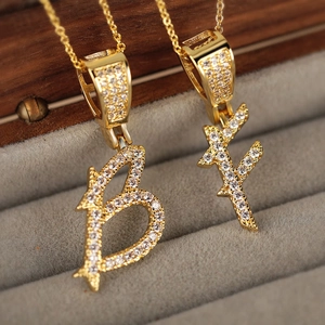 Gothic style gold pendant necklace featuring letter B and F with pave cubic zirconia