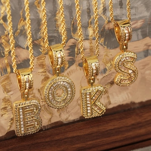 Iced out gold letter pendants with zircon stones on rope chains in hip hop style