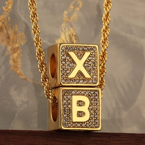 Collana hip-hop dorata con ciondoli lettere X e B ghiacciati su una catena a corda