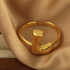 Anello regolabile placcato oro 18 carati con design fluido astratto su seta champagne