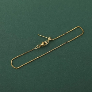Collana a catena box placcata oro regolabile con chiusura a moschettone su fondo verde