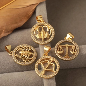 Pendentifs zodiaque plaqués or 18k avec zircons sertis sur fond de velours gris