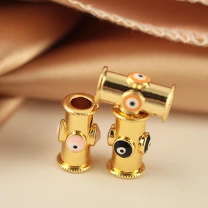 Three gold-plated evil eye barrel beads with colorful enamel on satin background