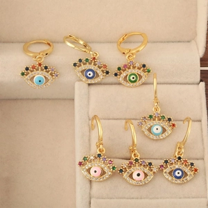 Goldene Evil Eye Creolen mit bunten Zirkoniasteinen in einer Schmuckschatulle
