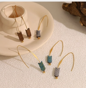 Macro detail of long curved hook earrings with colorful chevron arrow shaped pendants