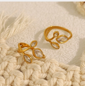 Detail of 18K gold-plated leaf ring with marquise-cut zircon stones on knit background
