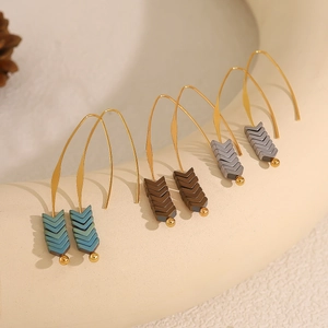 Retro multi-colored V-shaped arrow earrings with gold hooks on a ceramic ring
