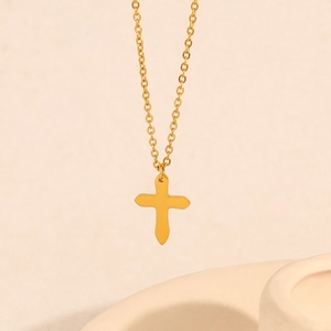 Minimalist gold stainless steel cross necklace with delicate O-chain on textured background