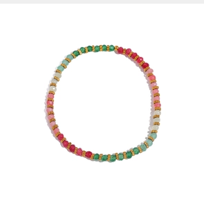 Macro detail of colorful faceted beads and golden spacers in a stretch bracelet set