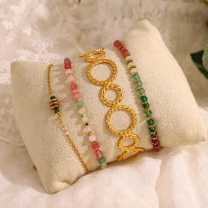 4-piece layered bracelet set with gold textured rings and colorful crystal beads