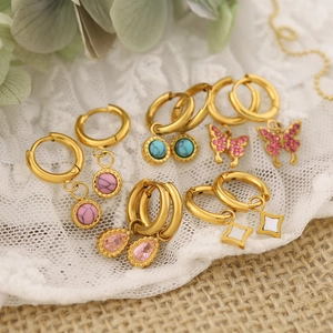 Gold-plated hoop earrings set with natural stones, butterfly charms on lace background