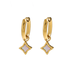 Macro view of gold hoop earrings with star charms featuring iridescent stone inlays