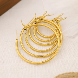 Detail of various sized gold bamboo texture hoop earrings with lever-back closures