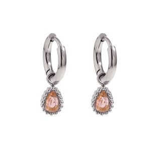 Detail of silver drop earrings featuring pear-shaped pink gemstones and beaded edging