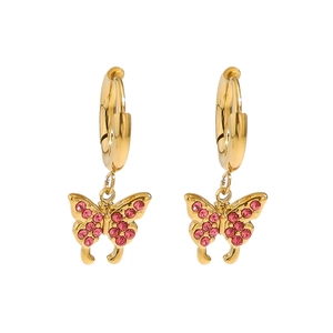 Macro view of gold hoop earrings featuring butterfly pendants with vibrant pink crystals