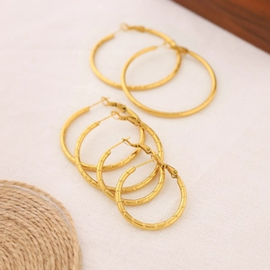 Detailed set of three golden bamboo textured hoop earrings in various sizes for women