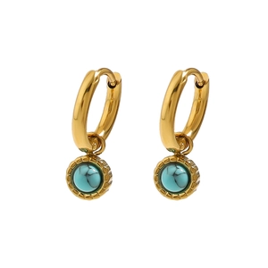 Detailed close-up of golden hoop earrings featuring vibrant blue round stone pendants