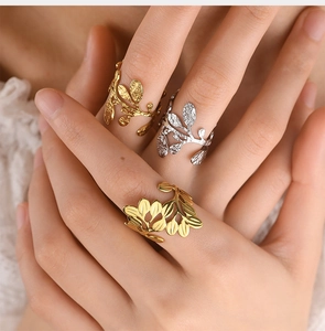 Close-up of gold and silver leaf-shaped open rings with polished and hammered textures