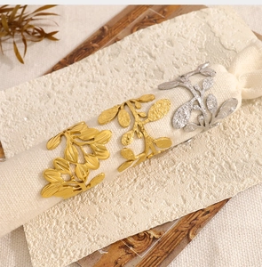 Macro shot of elegant gold and silver leaf-shaped napkin rings on white cloth