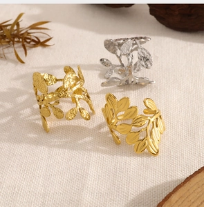 Macro detail of leaf-shaped metal rings in gold and silver finishes on linen fabric