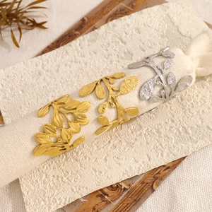 Elegant gold and silver leaf napkin rings with textured metal finish for dining decor