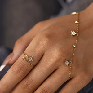 Detail van goudkleurige sieradenset met sterring en armband met zirkonia steentjes