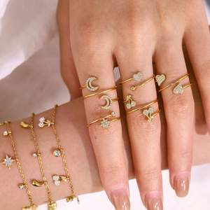 Detailweergave van gouden ringen en armbanden met ster-, maan- en hartvormige bedels