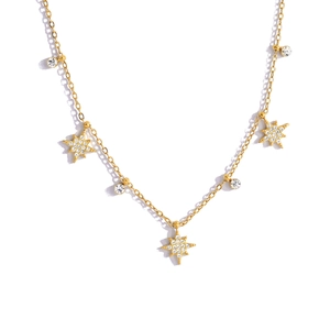 Macro-opname van gouden sterrenketting met zirkonia steentjes en verfijnde schakelketting