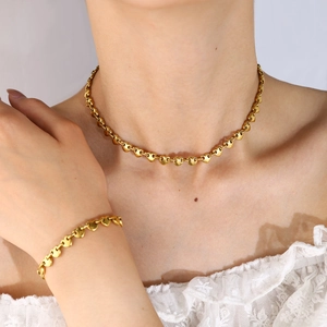 Conjunto de collar y pulsera con eslabones de corazón dorado lucido por una modelo