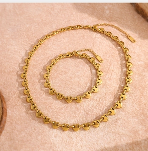 Vista detallada del conjunto de collar y pulsera de eslabones de corazón dorado