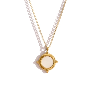Detail of vintage gold necklace with round white shell inlay and beaded texture