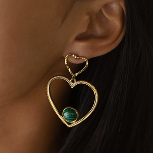 Dettaglio di orecchini a doppio cuore in oro 18K con malachite verde su una modella