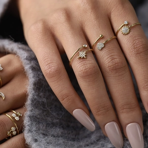 Detailed macro view of 18K gold plated star and heart rings with sparkling zircons