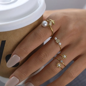 Three-piece stackable 18K gold-plated rings set featuring pearls and sparkling rhinestones