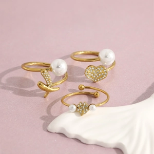 Three-piece 18K gold plated ring set with pearls, heart charms, and crystal stones
