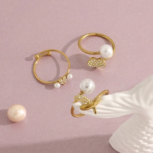 Close-up of elegant 18K gold-plated heart rings with pearls and sparkling crystals