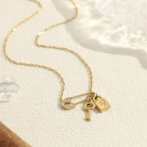 18K gold plated necklace featuring a crystal safety pin, key, and heart lock pendant