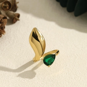 Irregular gold ring with leaf design and pear-cut emerald zircon in natural light
