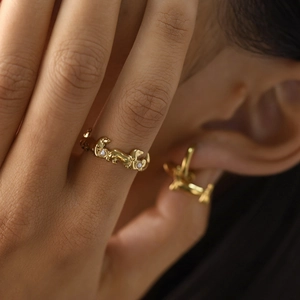 Anello a forma di bassotto dorato con perle della serie animali su sfondo minimalista