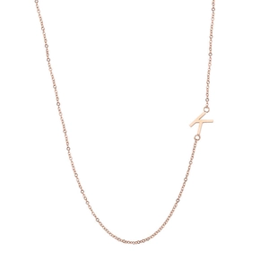 Détail du collier en or rose 18k avec un pendentif lettre K minimaliste suspendu sur le côté