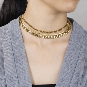 Detailed view of triple-layered gold stainless steel necklace with snake and figaro chains