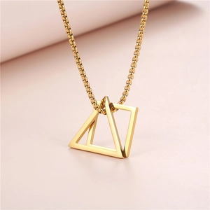 Détail macro du pendentif géométrique doré avec carrés et triangles sur une chaîne vénitienne
