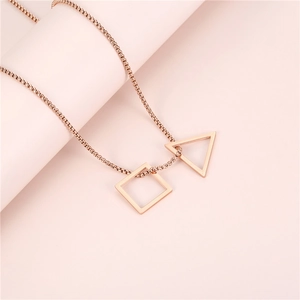Vue macro des pendentifs triangle et carré en or rose sur une fine chaîne en maille box