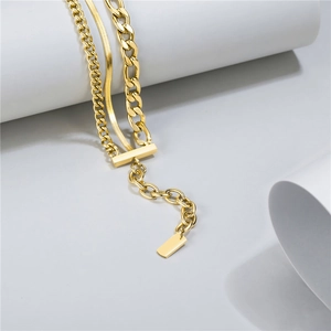 Detail of layered gold stainless steel necklace with thick curb chain and rectangular pendant