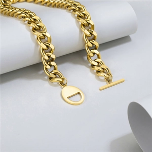 Detailed close-up of chunky gold stainless steel Cuban chain necklace with OT toggle clasp