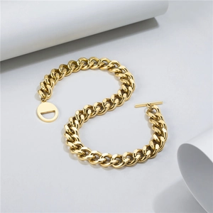Detailed shot of golden cuban link bracelet featuring a toggle clasp and round D pendant