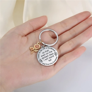 Macro view of sunflower keychain with motivational quote engraving on a silver disc
