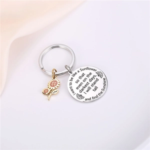 Sunflower stainless steel keychain with engraved round tag on soft pink fabric